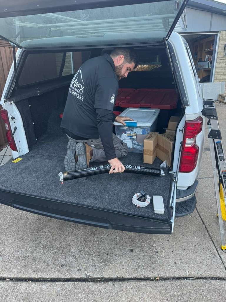 Garage door service technician performing installation and repair in Plano TX