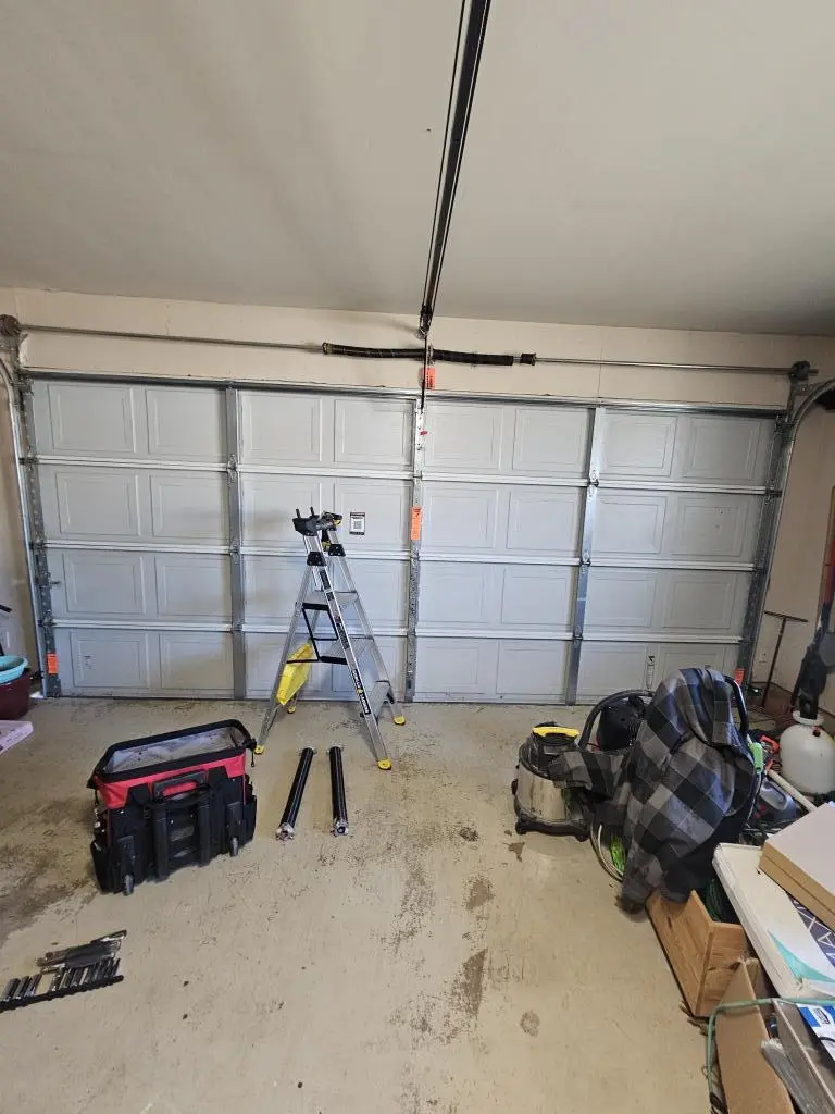 Close view of Garage Door Spring Replacement with new high-tension spring being installed for smooth door operation