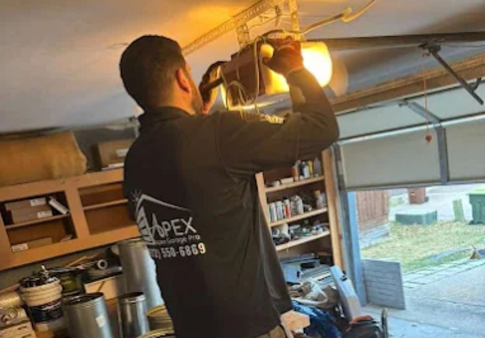 Technician installing a garage door opener in a McKinney garage