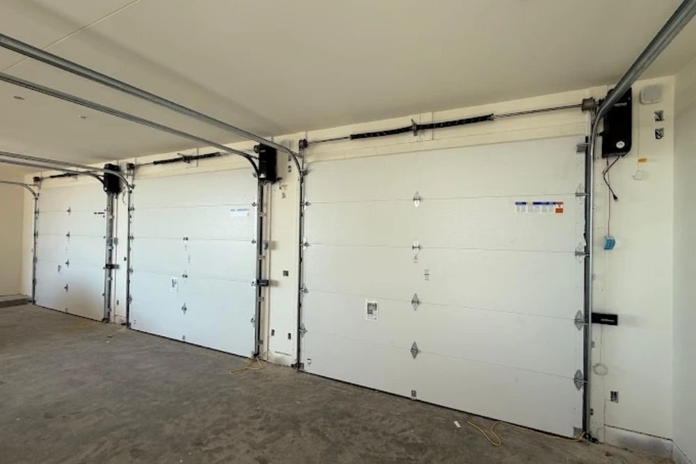 Insulated white garage doors in a multi-bay garage